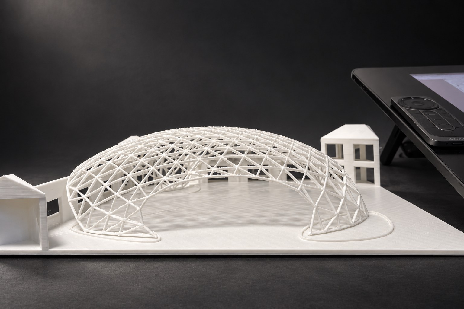 Nir Sivan Architects – 3D-printed model of the REUT Heart gridshell canopy (2025): the printed dome and its supports next to the digital model on a tablet